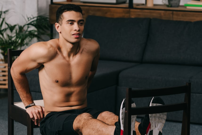 Man using chairs as part of his workout.